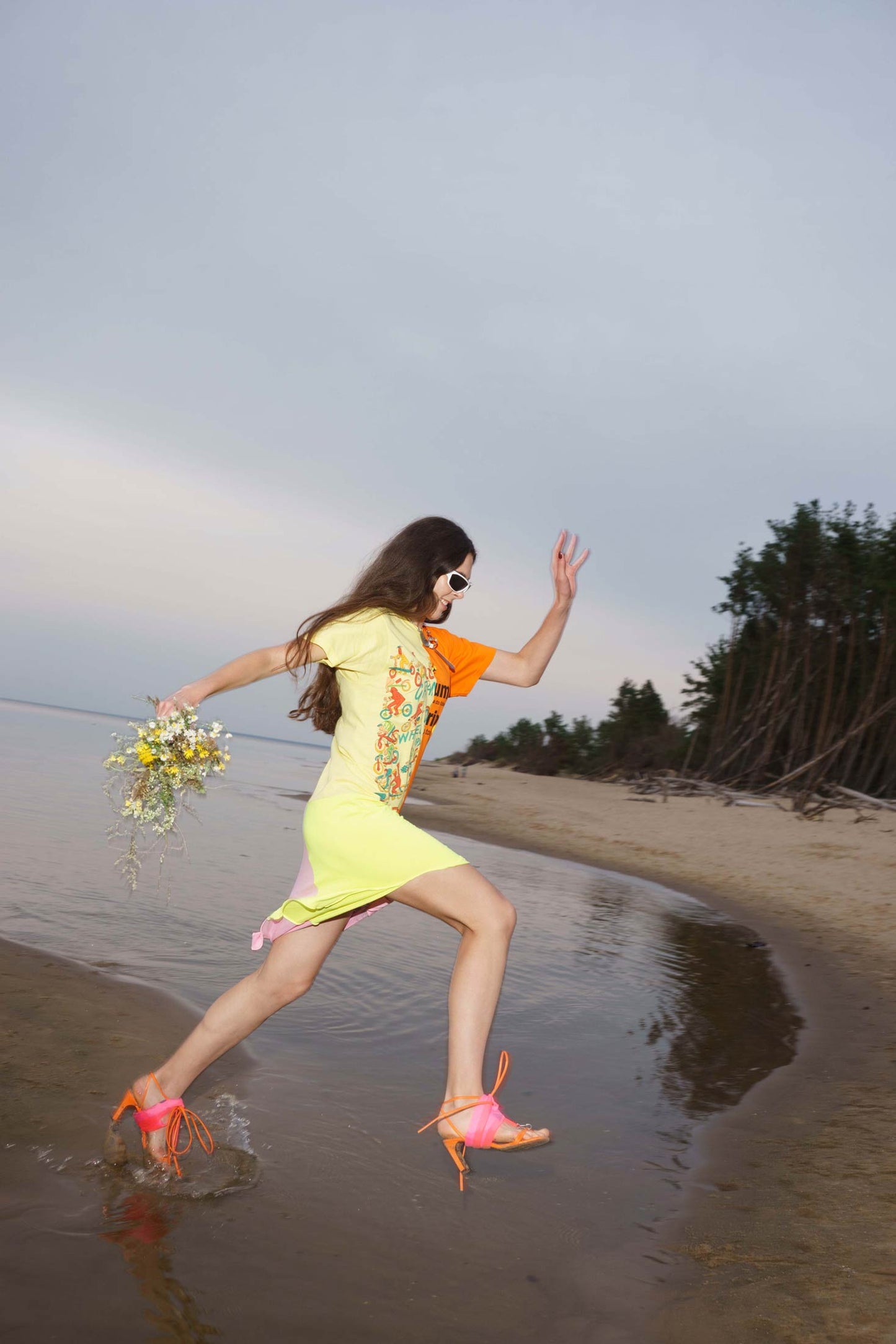 Multicolor upcycled t-shirt dress shown in movement, straight cut with asymmetrical hem.