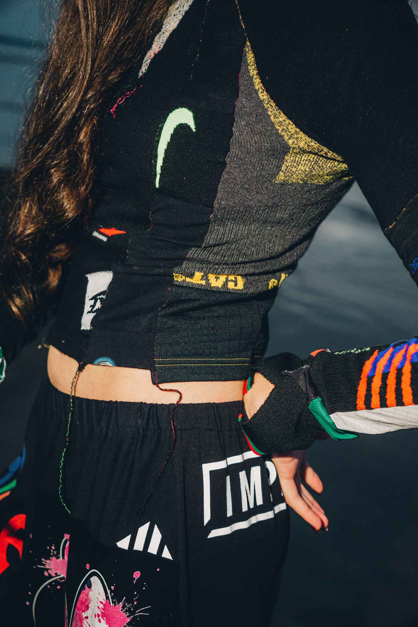 Close-up of graphic cotton t-shirt patchwork detail on black wide-leg trousers.