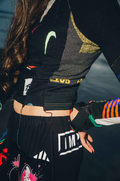 Close-up of graphic cotton t-shirt patchwork detail on black wide-leg trousers.