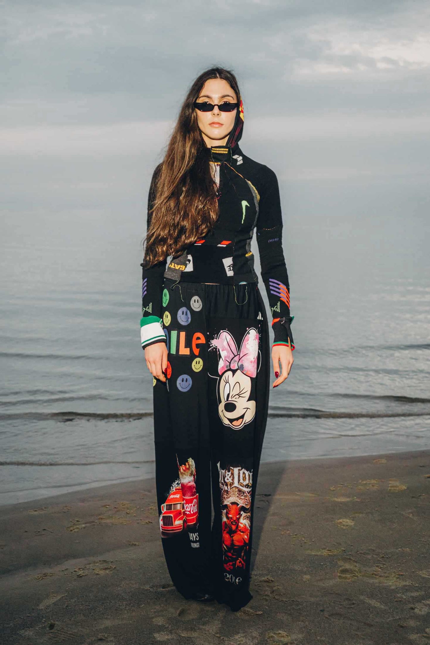 Black upcycled cotton wide-leg trousers made from vintage graphic t-shirts, shown on a model, front view.